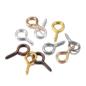 May include: Assortment of screw-in eyelet hooks in gold, silver, and bronze finishes. These hooks are ideal for attaching jewelry, charms, or other small items to projects.