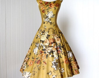 Vestido de los años 50, color dorado pulido, algodón acolchado, flores, pedrería, Marcel of Miami.