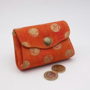 Porte-monnaie en accordéon à 3 compartiments réalisé à la main avec soin dans un tissu de grande qualité, gros pois dorés sur fond orange,