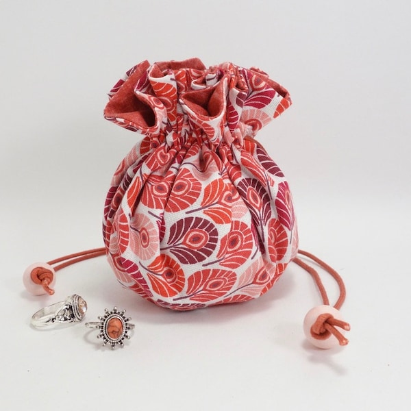 Pochette à bijoux ronde, aumônière en tissu, plumes stylisées dans des tons rouges et rose