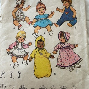 May include: A Simplicity 7208 sewing pattern envelope for 13-inch to 14-inch dolls. The front features illustrations of six dolls wearing various outfits including dresses, a yellow hooded sleeper, and bonnets, with line drawings of patterns.