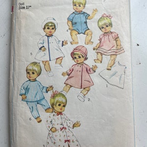 May include: A vintage Simplicity sewing pattern for a 17-inch doll. The pattern includes instructions for making a variety of outfits, including a blue romper, a pink dress, a white coat, a pink jacket, a striped pajama set, and a floral robe. The pattern number is 7931 and the price is 65 cents.