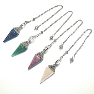 May include: Four gemstone pendulums with silver chains. The pendulums feature pointed crystal shapes in blue, green, pink, and light pink. Each pendulum has a decorative silver cap and a clear crystal bead. The chains have a small bead at the end.