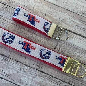 May include: Two red and white keychains with a bulldog and the text "LA TECH" printed on them. The keychains have gold and silver key rings.