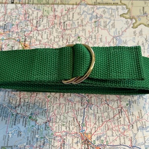 May include: A green woven webbing belt with a gold metal D-ring buckle.