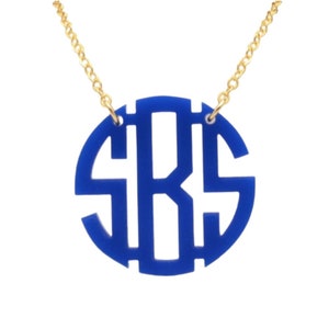 May include: A blue acrylic monogram necklace with a gold chain. The monogram is in a circle and the letters are "SRS".