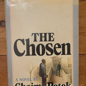 May include: A book cover with the title "The Chosen" by Chaim Potok. The cover features a black and white illustration of two men walking up a set of stairs.