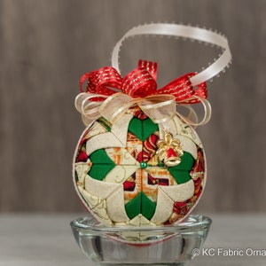 Quilted no sew fabric ornament - metallic poinsettia holiday fabric, red and gold bow, and a gold and red bell charm