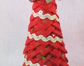 Tabletop quilted fabric Christmas tree decoration, red fabric with gold snowflake design, beige ric rac trim, colored sequins, gold bow