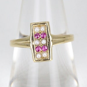 May include: A gold ring with a rectangular setting featuring pink gemstones and white pearls.