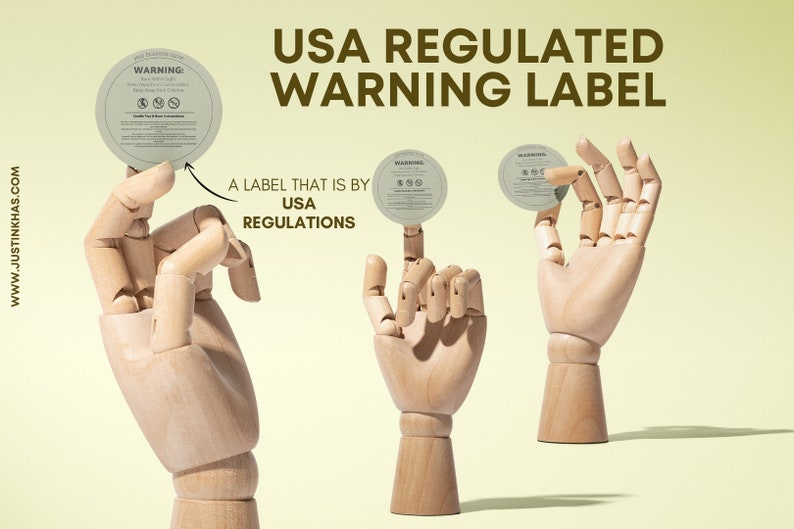 May include: Three wooden hands holding round, white warning labels with black text. The text on the labels reads "WARNING: Burn with Light Supervision. Keep Away From Children. Candle Specific Instructions". The text on the background reads "USA REGULATED WARNING LABEL" and "A LABEL THAT IS BY USA REGULATIONS".