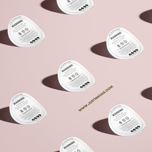May include: Multiple white round warning labels with black text and symbols. The text reads "WARNING:  This product contains ..." and includes a list of warnings. The labels are arranged in a grid pattern on a light pink background.