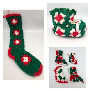 Puede incluir: Cuatro calcetines de Navidad tejidos a crochet en verde, rojo y blanco. Los calcetines están decorados con un patrón geométrico de cuadrados. Un calcetín tiene forma de bota, y los otros tres tienen formas de calcetines tradicionales.