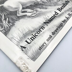 May include: A black and white illustration of a unicorn running through a forest. The book cover reads "A Unicorn Named Beulah" with the text "story and drawings by J. H. S."