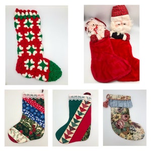 May include: A collection of five Christmas stockings. One stocking is crocheted with red and green squares. Another stocking is red velvet with a white trim. A third stocking is green and red with a patchwork design. A fourth stocking is blue and green with a floral pattern. The fifth stocking is beige with a floral pattern and a blue ruffle.