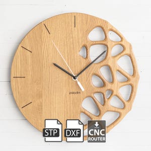 Op de afbeelding: Een ronde houten klok met een uniek open ontwerp aan de rechterkant. De klok heeft zwarte wijzers en minimalistische uurmarkeringen. Het woord "palodim" staat op de wijzerplaat. De klok is gemaakt van lichtbruin hout.