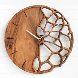 Könnte beinhalten: Eine runde Holzuhr mit einem einzigartigen Design. Das Zifferblatt ist teilweise aus massivem Holz und teilweise offen, mit einem geometrischen Muster. Die Zeiger sind weiß, und der Markenname "paladin" ist auf dem Zifferblatt aufgedruckt.