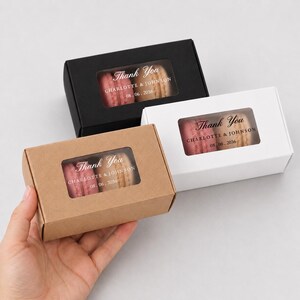 May include: Three rectangular gift boxes in black, white, and kraft brown, each featuring a clear window displaying two macarons. The boxes are printed with the text Thank You, Charlotte & Johnson, and the date 08.06.2036 on the window surface.