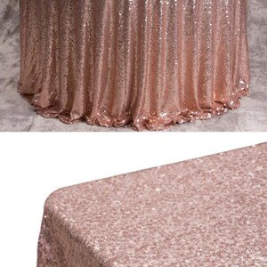 May include: A rose gold sequin tablecloth. The tablecloth is round and has a smooth, shiny surface.