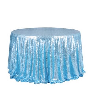 Könnte beinhalten: Eine runde Tischdecke aus hellblauen Pailletten. Die Tischdecke ist aus einem schimmernden Stoff mit einem dezenten Glanz.