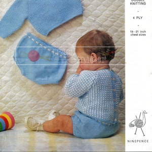 May include: A knitting pattern for a baby sweater and pants set. The pattern is for a blue sweater with a white and blue pattern and blue pants with a pink circle design. The pattern is called "Emu" and is for sizes 19-21 inches chest. The pattern is from a vintage knitting book.