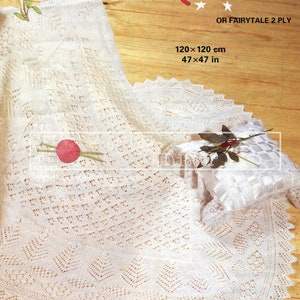 May include: A white crocheted baby blanket with a delicate lace pattern. The blanket is laid out on a wooden surface with a ball of yarn and knitting needles. The text "Patons FAIRYTALE 3 PLY" and "OR FAIRYTALE 2 PLY" is visible on the image. The blanket measures 47 x 47 inches.