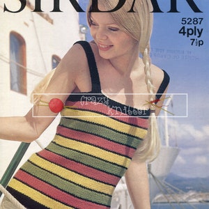 May include: A striped knit top with black, yellow, green, and pink stripes. The top has a scoop neck and thin straps. The model is wearing the top with white jeans and has blonde hair.