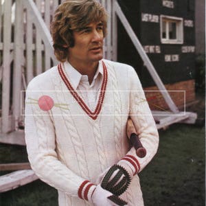 May include: A white cable knit sweater with red and white stripes on the collar and cuffs. The sweater has a V-neck and is being worn by a person holding a cricket bat. The text "PATONS Double Knitting 38-44 in." is visible at the top of the image.