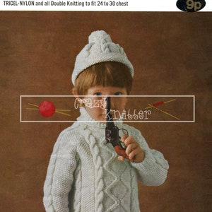 May include: A white knitted sweater with a cable knit pattern and a turtleneck. The sweater is being worn by a child wearing a white knitted hat with a pom-pom on top. The child is holding a toy gun. The image includes the text "ROBIN", "TRICEL-NYLON and all Double Knitting to fit 24 to 30 chest", "1578", and "9p".