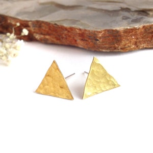 May include: A pair of gold triangle earrings with a hammered texture.