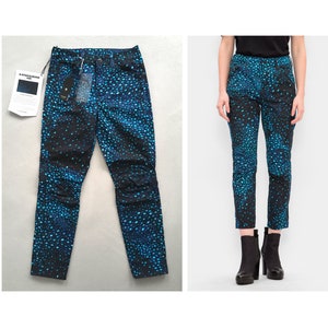 Puede incluir: Vaqueros ajustados de color azul y negro con un estampado de lunares azules. Los vaqueros tienen una etiqueta de G-Star RAW en el bolsillo trasero.