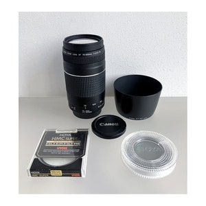 Pode incluir: Uma objetiva zoom Canon EF 75-300 mm f/4-5,6 III preta com uma ombreira preta, uma tampa de objetiva Canon preta e um filtro UV(0) Hoya transparente. O filtro está na sua embalagem original.