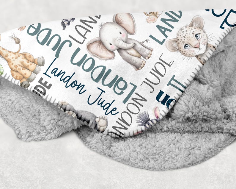 a blanket with various animal illustrations, including elephants, giraffes, and leopards, along with the name "Landon" written on it.