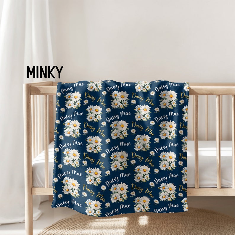 a baby crib with a blanket with daisies on it