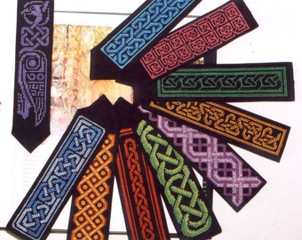 Puede incluir: Una colección de marcapáginas hechos a mano con diseños de nudos celtas. Cada marcapáginas presenta un fondo negro con un patrón de color diferente, incluyendo azul, rojo, verde y naranja. Los marcapáginas están hechos de material tejido.