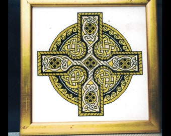 May include: Framed artwork featuring a Celtic cross design. The cross is intricately detailed with interwoven patterns in gold, black, and white, set against a white background. The artwork is encased in a gold-colored wooden frame.