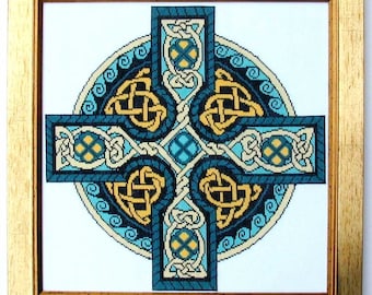 May include: Framed cross-stitch artwork featuring a Celtic cross design. The cross is in shades of teal, gold, and cream, with intricate knotwork patterns. The artwork is set within a gold-colored wooden frame, creating a decorative piece.