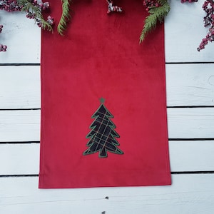 Puede incluir: Camino de mesa navideño rojo con una aplicación de árbol de Navidad a cuadros. El árbol está delineado en verde y tiene una estrella verde. El camino de mesa es rectangular y de tela suave.