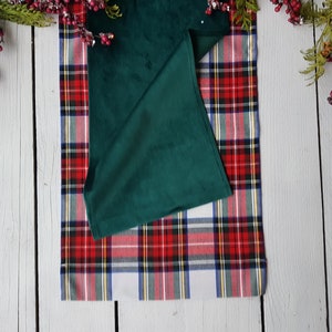 May include: A green velvet table runner with a red and white plaid pattern underneath. The runner is folded in half and the plaid pattern is visible on both sides.