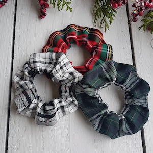 Può includere: Tre scrunchies in tessuto a quadri. Uno è rosso e bianco, uno è nero e bianco e uno è verde e bianco.