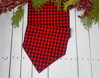 May include: Red and black buffalo plaid table runner. The runner is folded in half and has a pointed end.