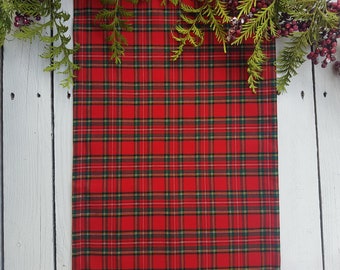 May include: Red and green plaid table runner with a white background. The runner is made of a soft, woven fabric and has a classic plaid pattern.