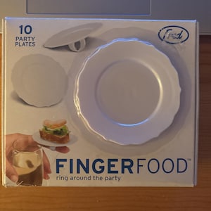 May include: A package of 10 white party plates with a unique ring design. The box features the text "FINGERFOOD" and "ring around the party". The image shows a small sandwich and a glass of a dark beverage.