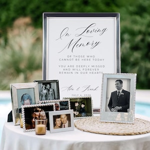 Puede incluir: Una exhibición conmemorativa con un letrero que dice "In Loving Memory" y fotografías enmarcadas. El letrero incluye los nombres "Ava & Frank" y la fecha "4 de julio de 2026". Las fotos están en marcos plateados y blancos.