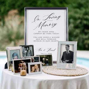 以下が含まれることがあります： 「In Loving Memory」と書かれた看板と額入りの写真が特徴の追悼展示。看板には「Ava & Frank」と日付「2026年7月4日」が記載されています。写真は銀色と白のフレームに入っています。