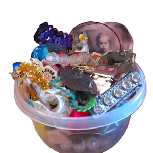 May include: A white ceramic mug with a black handle and the text "But First, Coffee" in a bold, black font. The mug is set against a blurred background, suggesting a cozy setting.