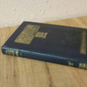 May include: A blue hardcover book with gold lettering on the spine. The title of the book is "The Art of Advertising".