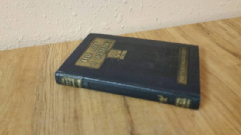 May include: A blue hardcover book with gold lettering on the spine. The title of the book is "The Art of Advertising".