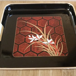 Bandeja cuadrada pequeña para servir, hecha en Japón, lacada en rojo y negro, con asas envueltas en bambú