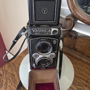 May include: A set of three ceramic mugs with a speckled, matte finish. The mugs are in shades of cream, light gray, and dark gray. Each mug has a simple, modern design and a rounded handle.